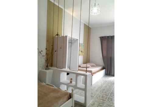 ein Zimmer mit zwei Betten und einem Spiegel in der Unterkunft Overhill Apartments Adamas in Adamas