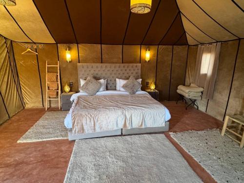 a bedroom with a bed in a tent at Erg Chebbi Sahara Camp in Merzouga