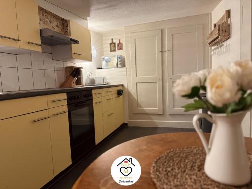 a kitchen with a vase of flowers on a table at Family M Apartments 16-17-18 in Sempach