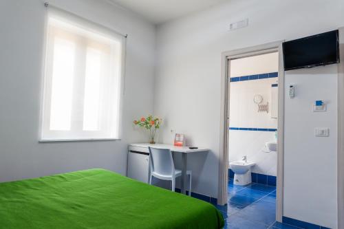 a bedroom with a bed and a desk and a toilet at Settessenze Residence & Rooms in Agropoli