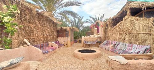 a living room with couches and a fire pit at siwa gardenia cottage in Siwa