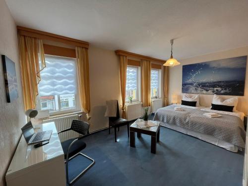 a bedroom with a bed and a desk and windows at 200qm großes Ferienhaus zwischen Goitzsche & Wörlitzer Park in Steinfurth