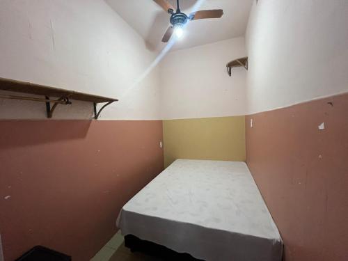 Cama en habitación con ventilador de techo en Quarto simple em Ipanema, en Río de Janeiro
