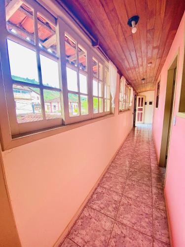 an empty hallway with windows in a train at Hospedaria Vila Rica - 1 km do centro histórico in Ouro Preto