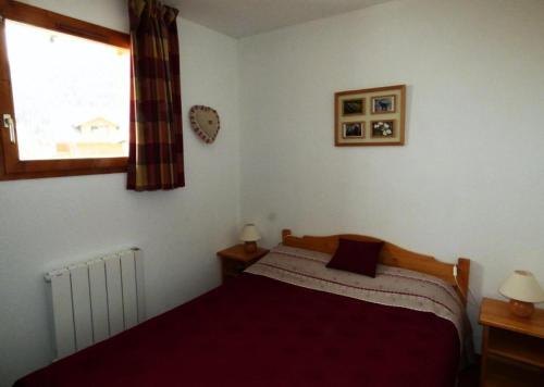 una camera con letto e finestra di Les Chalets D'arrondaz - 3 Pièces pour 6 Personnes 39 a Modane