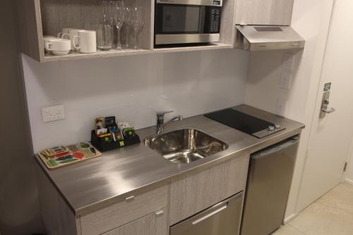 a small kitchen with a sink and a microwave at Quest Nelson in Nelson