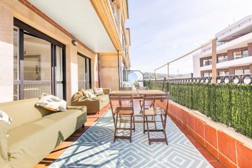 a balcony with a couch and a table and chairs at Playa, río y monte en 1ª linea in Orio