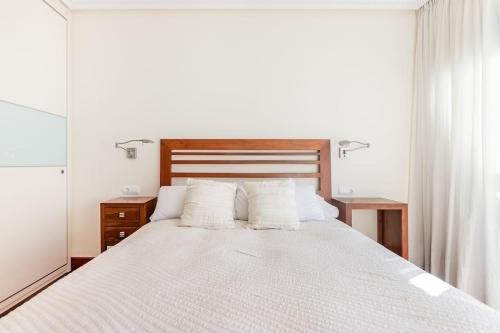 a bedroom with a large white bed with two pillows at Playa, río y monte en 1ª linea in Orio