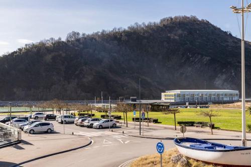 a parking lot with cars parked in front of a mountain at Playa, río y monte en 1ª linea in Orio