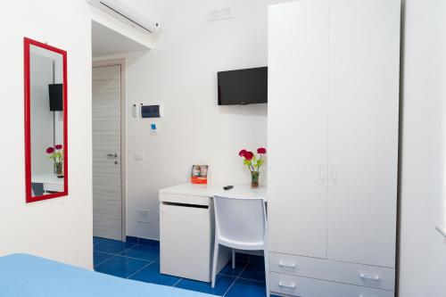a white kitchen with a table and a chair at Settessenze Residence & Rooms in Agropoli