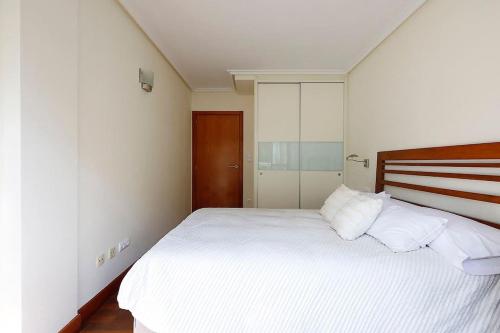 a bedroom with a large bed with white sheets and pillows at Playa, río y monte en 1ª linea in Orio