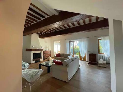 uma sala de estar com um sofá branco e uma lareira em L'Antico casale dell'800 em Albinia