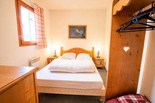 a bedroom with a bed with white sheets and pillows at Résidence Belvedere Busseroles - RESIDENCE LE BELVEDERE "BUSSEROLES" - BELVB06 MAE-3071 in Modane