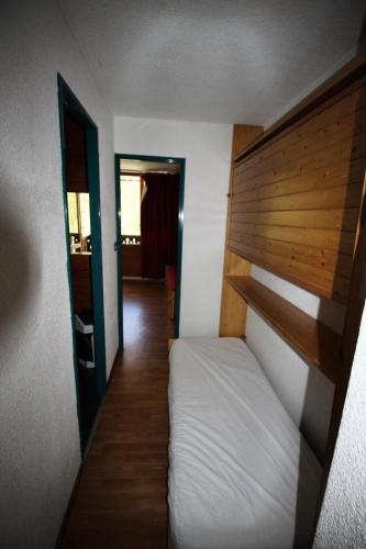 une petite chambre avec un lit et une tête de lit en bois dans l'établissement Résidence Thabor D - THABOR D - THAD154 MAE-3088, à Modane