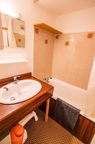 une salle de bain avec un lavabo et une baignoire dans l'établissement Résidence Les Arolles - LES AROLLES - AR24B MAE-3099, à Villarodin-Bourget