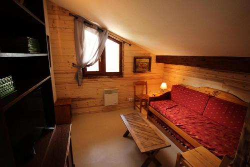 sala de estar con sofá rojo y ventana en Chalet Arrondaz I - 5 Pièces pour 12 Personnes 193096, en Modane