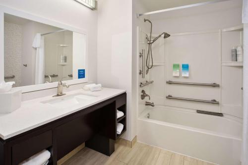 a bathroom with a sink and a tub and a mirror at Home2 Suites by Hilton Austin/Cedar Park in Cedar Park