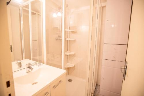 Un baño blanco con ducha y lavabo. en Résidence Les Arolles - LES AROLLES - AR40A MAE-3104, en Villarodin-Bourget