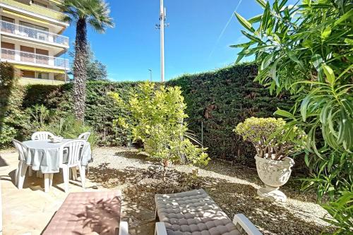 d'une terrasse avec une table et des chaises dans le jardin. dans l'établissement 2 bdr apartment with garden next to the Croisette, à Cannes