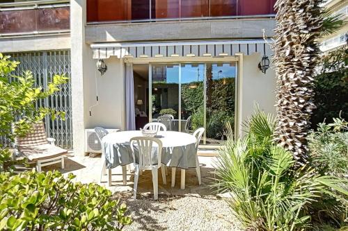 un patio avec une table et des chaises sur un patio dans l'établissement 2 bdr apartment with garden next to the Croisette, à Cannes