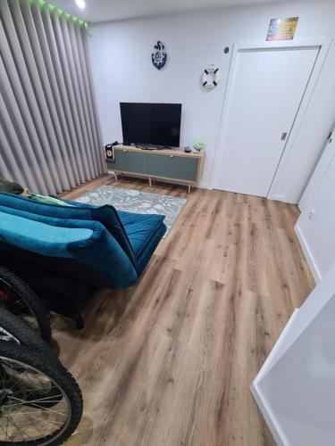 a living room with a wooden floor and a television at Apartamento 50mt Praia Póvoa Varzim in Póvoa de Varzim