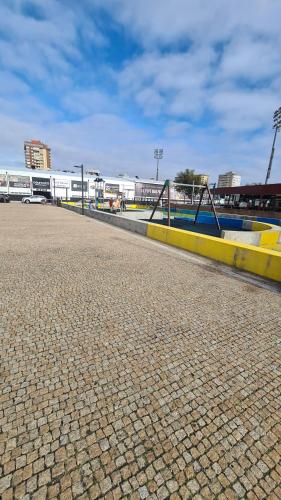 a cobblestone street with a building in the background at Apartamento 50mt Praia Póvoa Varzim in Póvoa de Varzim