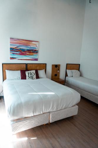 a bedroom with a large white bed and a couch at Hostel Sweet Home Palermo Soho in Buenos Aires