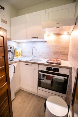 une cuisine avec un évier et une cuisinière dans l'établissement Résidence Les Campanules - LES CAMPANULES - CA11FC MAE-3147, à Villarodin-Bourget