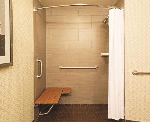 a shower with a wooden bench in a bathroom at DoubleTree Suites by Hilton Hotel Austin in Austin