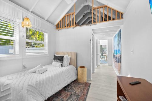 a white bedroom with a bed and a desk at 29 Palms in Anna Maria