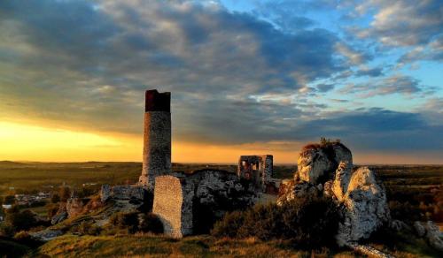 um antigo edifício de pedra numa colina com um pôr-do-sol em White House em Czestochowa