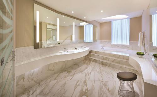 een badkamer met 2 wastafels en een grote spiegel bij DoubleTree by Hilton Doha Old Town in Doha