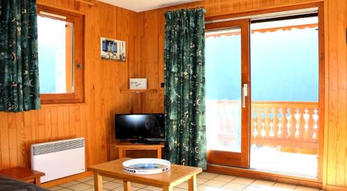 un salon avec une télévision et une fenêtre dans l'établissement Résidence Le Chardonnet - Appartement à 200 m des psites avec belle vue MAE-3276, à Champagny-en-Vanoise