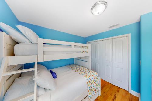 a bedroom with two bunk beds and blue walls at Gulf Breeze Getaway in Saint Joe Beach