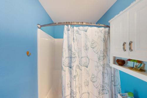 a shower curtain in a bathroom with a blue wall at Gulf Breeze Getaway in Saint Joe Beach