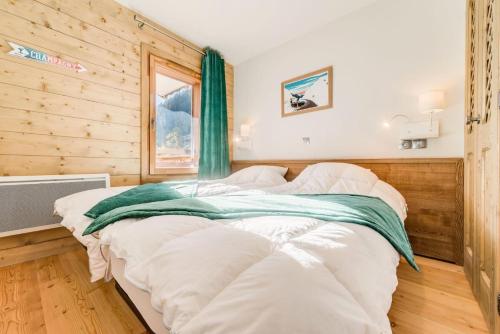 - un grand lit dans une chambre dotée d'un mur en bois dans l'établissement Résidence Les Balcons EtoilÉs - Appartement 4 au pied des pistes MAE-3261, à Champagny-en-Vanoise