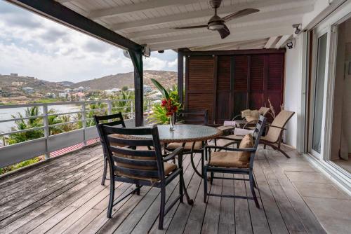 a patio with a table and chairs on a balcony at Les Balcons d'Oyster Pond in Saint Martin