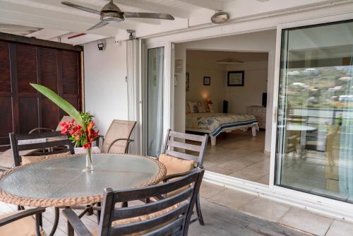 a patio with a table and chairs and a bedroom at Les Balcons d'Oyster Pond in Saint Martin