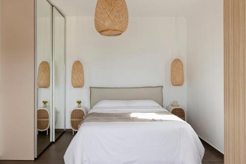 a bedroom with a white bed and a mirror at Mytakas Houses in Mytakas