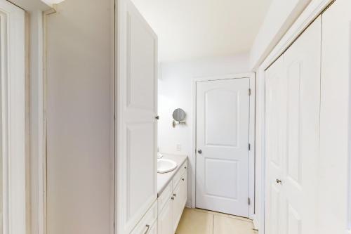 a white bathroom with a sink and a white door at Regency Towers W 707 in Pensacola Beach