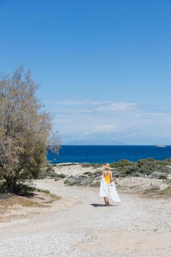 a woman in a wedding dress walking on the beach at Mytakas Houses in Mytakas