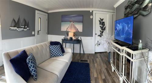 ein Wohnzimmer mit einem weißen Sofa und einem TV in der Unterkunft Beautiful Oceanview Retreat 2 Bedroom Home in Port Hadlock