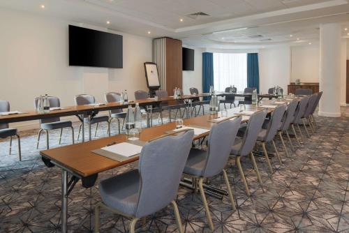 a conference room with tables and chairs and a projection screen at DoubleTree by Hilton London Angel Kings Cross in London
