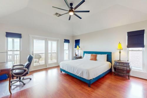a bedroom with a bed and a desk and a ceiling fan at Sunrise in Paradise in Galveston