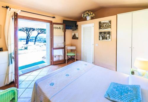 een slaapkamer met een bed en een groot raam bij La Casa del Mirto in Palau