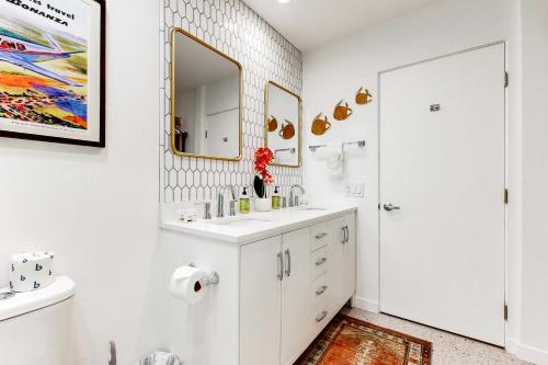 a white bathroom with a sink and a mirror at Mountain Cove Modern in Indian Wells