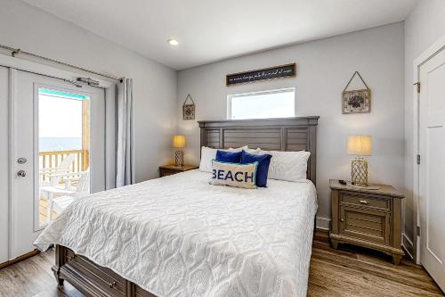 - une chambre avec un grand lit et une fenêtre dans l'établissement Bienville Beach Compound, à Dauphin Island