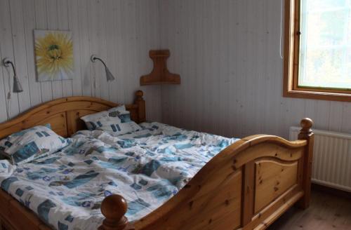 1 dormitorio con 1 cama grande con sábanas azules en Rustikales Landhaus mit Terrasse in einzigartiger Naturlandschaft nahe der Küste mit Anlegeplatz, ideal zum Angeln - b57903, en Loftahammar