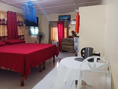 a bedroom with two beds and a table and a mirror at Tina's Guest House in Ocho Rios