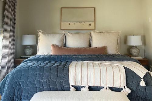a bedroom with a blue bed with two lamps at Peaceful Retreat on Quiet Cove on Lake Travis in Lakeway